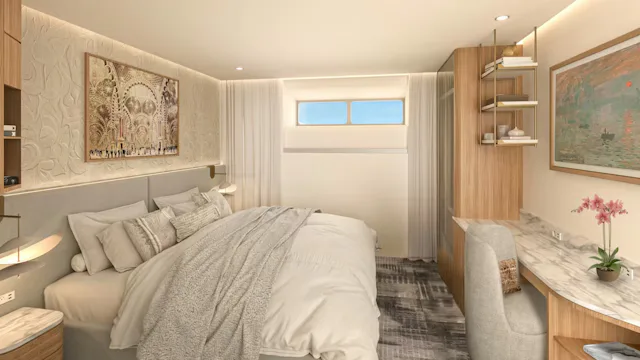 Moderne hut aan boord van een Celebrity Cruises schip met comfortabel tweepersoonsbed, bureau en stijlvolle inrichting.